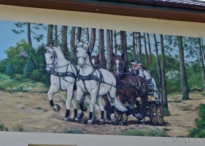 Mural z końmi wykonany na elewacji domu mieszkalnego.