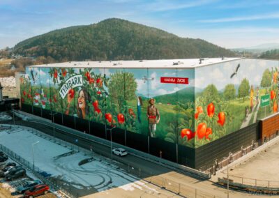 epicki mural w Tymbarku wykonany dla Maspex - sady z jabłkami, bocian, budynki, jeden z największych i najładniejszych murali w Polsce