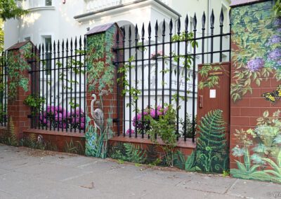 pomalowany murek - mural na cegłach przedstawiający motywy roślinne oraz ptaki