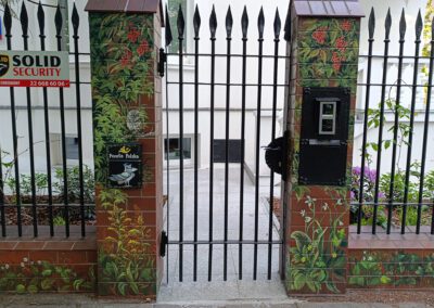 pomalowany murek - mural na cegłach przedstawiający motywy roślinne oraz ptaki